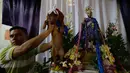 Seorang pria mengangkat anjingnya di depan altar untuk diberkati selama misa untuk San Lazaro di Monimbo, Masaya, Nikaragua (18/3). Acara misa ini dilakukan setiap tahun dengan membawa hewan peliharaan mereka. (AFP/Inti Ocon)