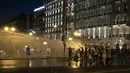 Polisi Yunani menggunakan meriam air untuk membubarkan pengunjuk rasa anti-vaksin selama rapat umum di alun-alun Syntagma, Athena tengah (24/7/2021). Pengunjuk rasa menentang vaksinasi wajib bagi para pekerja, seperti staf tenaga kesehatan dan perawat. (AP Photo/Yorgos Karahalis)