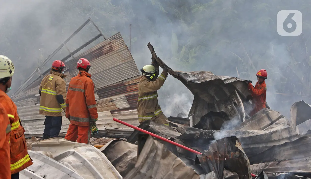 Petugas pemadam kebakaran melakukan pendingin di Pabrik penggilingan kapas,  Pasar Rebo, Jakarta Timur, Selasa (16/11/2021). Api melalap Pabrik penggilingan kapas yang di sebabkan korsleting pada panel listrik. (Liputan6.com/Herman Zakharia)