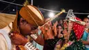 Sepasang pengantin menjalani ritual dalam prosesi pernikahan massal umat Hindu di Karachi, Pakistan, (19/3). Sebanyak 62 pasangan pengantin mengikuti pernikahan massal yang merupakan bagian dari perayaan Festival Holi. (AFP Photo /Asif Hassan)