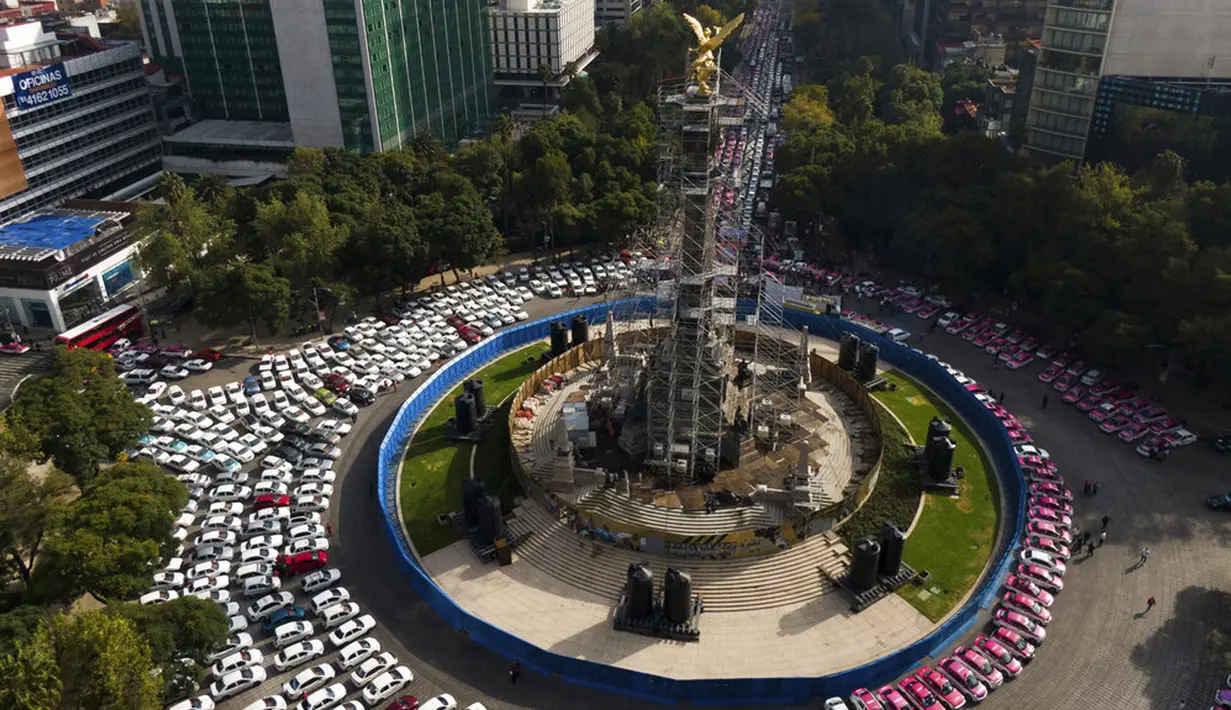 Sopir taksi memblokir bundaran monumen Angel of Independence di Jalan Paseo de la Reforma, Mexico City, Meksiko, Senin (12/10/2020). Para sopir taksi menuntut kondisi yang sama dengan layanan transportasi online, seperti peraturan dan biaya pemerintah. (AP Photo/Fernando Llano)