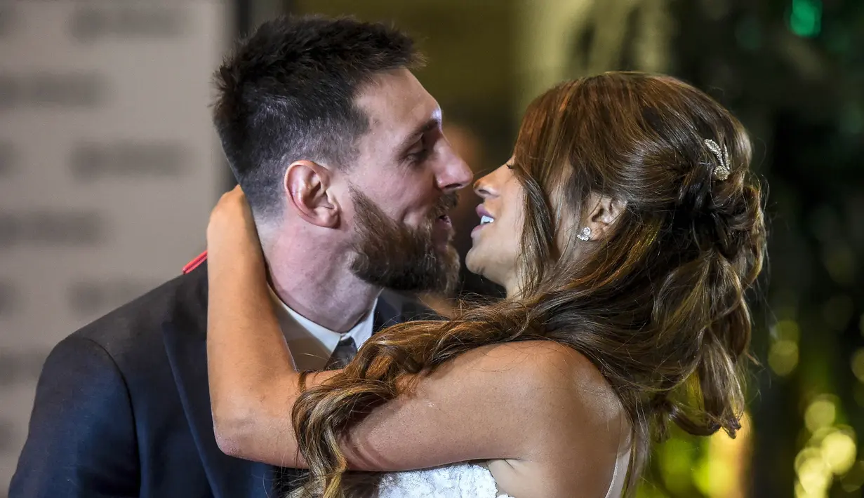 Bintang Barcelona, Lionel Messi, mencium bibir sang istri, Antonella Roccuzzo, dihadapan wartawan usai mengadakan resepsi pernikahan di Kompleks City Center, Santa Fe, Jumat (30/6/2017). (AFP/Eitan Abramovich)
