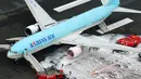 Gambar udara menunjukkan petugas pemadam kebakaran menyemprotkan busa pada mesin pesawat Korean Air Lines setelah asap keluar dari bagian mesin sebelah kiri itu di bandara Haneda di Tokyo, Jepang, (27/5). (Reuters/ Kyodo)