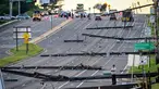 Pemandangan arah timur dari Route 97, seorang pria berdiri melihat tiang listrik yang tumbang di Route 140, Westminster, Maryland, Amerika Serikat, Selasa (8/8/2023). Tiang listrik bertumbangan setelah badai dahsyat melanda area tersebut pada Senin malam. (Jerry Jackson/The Baltimore Sun via AP)