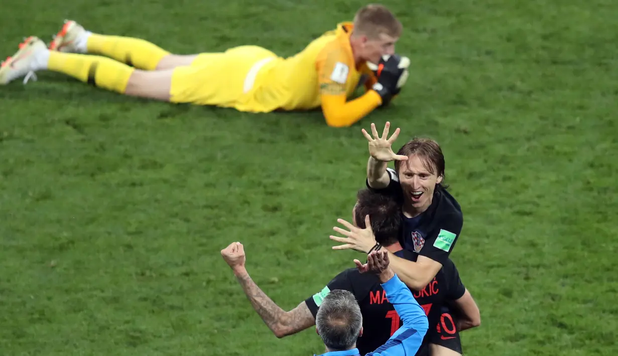 Kapten timnas Kroasia, Luka Modric berselebrasi dekat kiper Inggris, Jordan Pickfor seusai babak semifinal Piala Dunia 2018 di Stadion Luzhniki, Rabu (11/7). Kroasia memastikan diri maju ke final seusai mengandaskan Inggris 2-1. (AP/Thanassis Stavrakis)