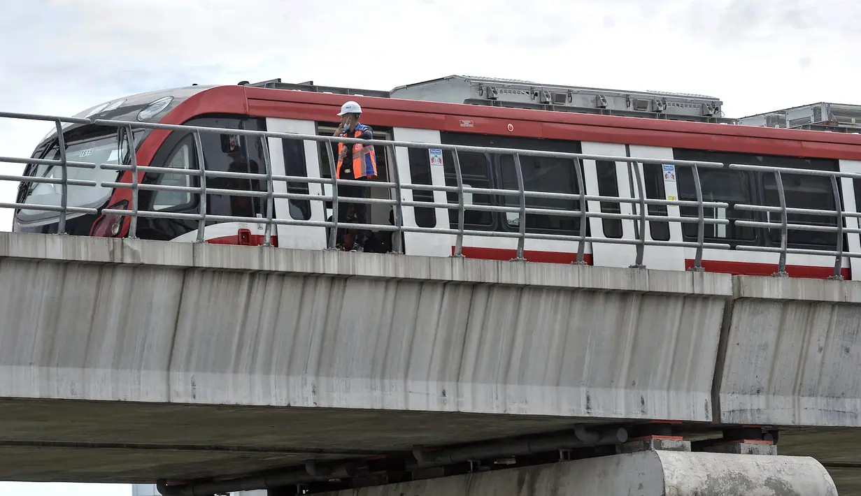 Petugas berada dekat rangkaian LRT Jabodebek saat uji beban di Jembatan Bentang Panjang kawasan Kuningan-Jalan Gatot Subroto, Jakarta Selatan, Kamis (24/2/2022). Jembatan sepanjang 148 meter tersebut diklaim sebagai yang terpanjang di dunia. (merdeka.com/Iqbal S. Nugroho)