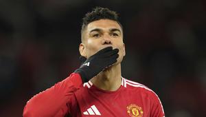 Gelandang Manchester United (MU), Casemiro, menyapa suporter di Old Trafford saat ditarik keluar dalam laga melawan Real Sociedad pada leg kedua 16 besar Liga Europa 2024/2025, Jumat (14/3/2025) dini hari WIB. (AP Photo/Dave Thompson)