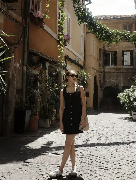 Dengan little black dress, ia tampil begitu manis. Paduan sneakers hadirkan gaya yang chic. [Foto: Instagram/ Aaliyah Massaid]