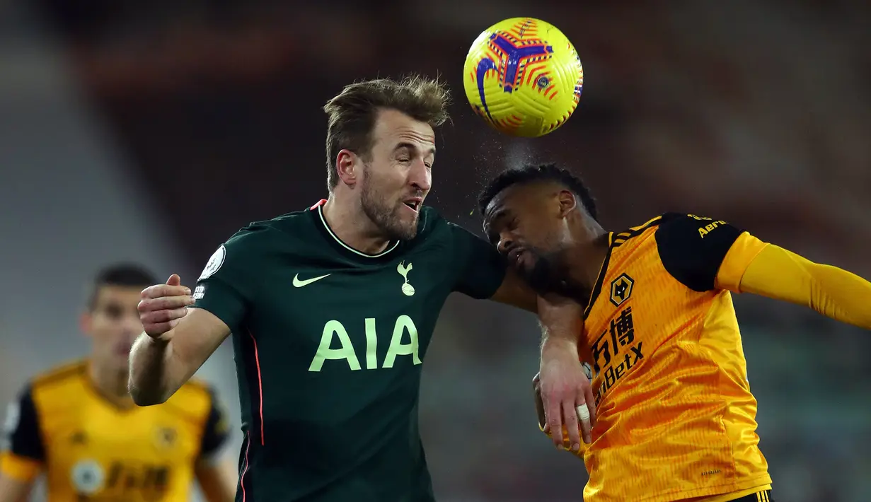 Striker Tottenham Hotspur, Harry Kane (kiri) berduel udara dengan bek Wolverhampton Wanderers, Nelson Semedo dalam laga lanjutan Liga Inggris 2020/21 pekan ke-15 di Molineux Stadium, Minggu (27/12/2020). Tottenham bermain imbang 1-1 dengan Wolves. (AFP/Michael Steele/Pool)