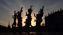 Para wanita muda menari tarian kelompok saat matahari terbenam di Palace Square, St. Petersburg, Rusia, Kamis (24/9/2020). (AP Photo/Dmitri Lovetsky)