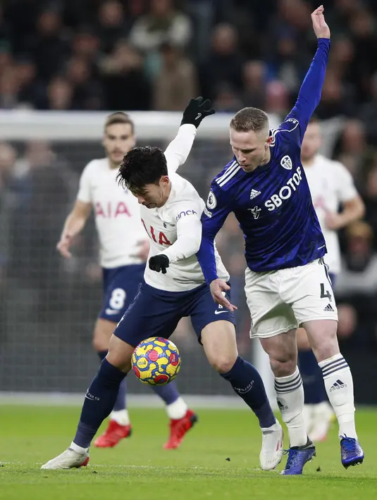 Gelandang Leeds United Adam Forshaw berebut bola dengan penyerang Tottenham Hotspur, Son Heung-min pada pekan ke-12 Liga Inggris di Tottenham Hotspur Stadium, London, Minggu (21/11/2021). Sempat tertinggal, Tottenham Hotspur menumbangkan Leeds United 2-1. (AP Photo/Ian Walton)