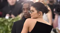 Kylie Jenner memeluk sang kekasih, Traviz Scott saat berpose untuk fotografer setibanya pada ajang Met Gala 2018 di Metropolitan Museum of Art New York, Senin (7/5). Kylie Jenner dan Travis Scott serasi tampil serba hitam. (Evan Agostini/Invision/AP)