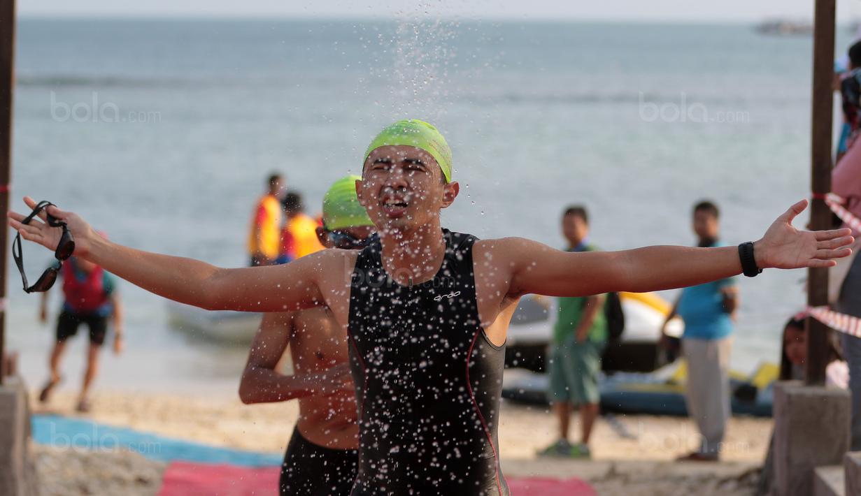 Peserta memasuki shower usai melakukan berenang Psaat mengikuti Rhino Cross Triathlon pada Festival Pesona Tanjung Lesung 2017 di Tanjung Lesung, Banten (24/9/2017). Total jarak tempuh Rhino Cross Triathlon 38 km. (Bola.com/Nicklas Hanoatubun)