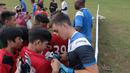 Usai beratih anak-anak berburu tanda tangan kiper Espanyol B, Eduardo Frias di Lapangan  AKRI, Ampera, Jakarta, Minggu (16/7/2017). Coaching Clinic ini diikuti oleh puluhan anak dari SSB Tik Tak. (Bola.com/Nicklas Hanoatubun)