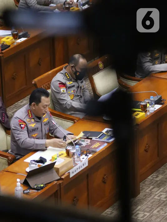 Kapolri Jenderal Pol Listyo Sigit Prabowo (kiri) mengikuti rapat kerja bersama Komisi III DPR di di Kompleks Parlemen Senayan, Jakarta, Senin (24/1/2022). Raker terkait evaluasi kinerja dan capaian Polri selama tahun 2021, serta rencana penggunaan anggaran 2022. (Liputan6.com/Angga Yuniar)