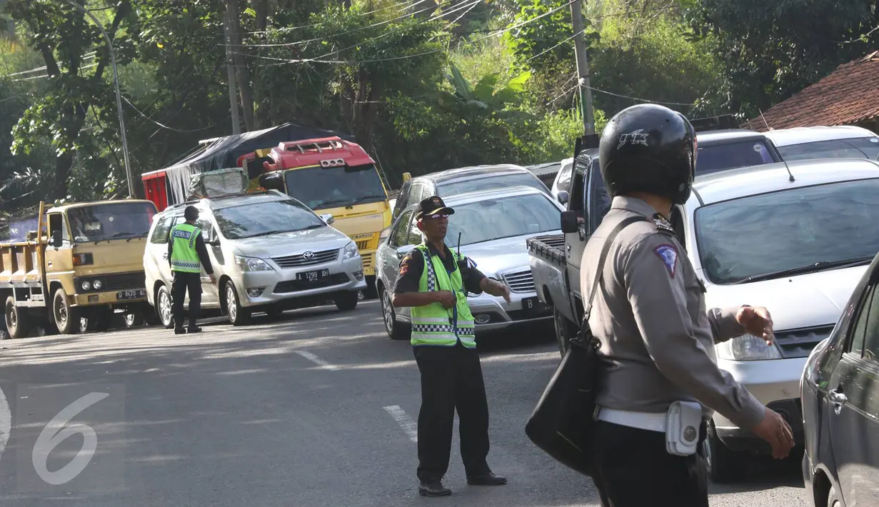 Petugas berusaha mengatur kemacetan kendaraan yang melintas di jalur lingkar Nagreg, Jawa Barat, Sabtu (2/7). Kemacetan disebabkan bus pemudik yang mengalami kecelakaan hingga menutup sebagian jalur. (Liputan6.com/Immanuel Antonius)