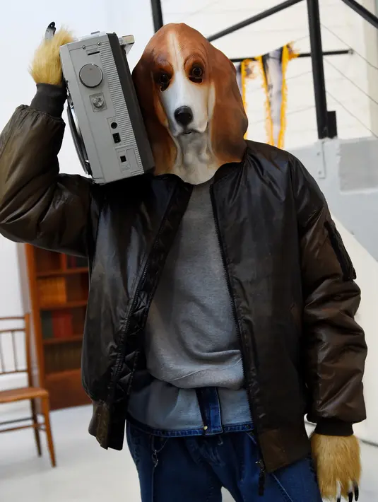 Seorang model mengenakan topeng anjing berpose saat membawakan kreasi Julien David untuk koleksi Fall / Winter 2018/2019 dalam Paris Men Fashion Week di Paris (17/1). (AFP Photo/Bertrand Guay)