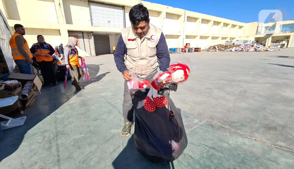 Petugas organisasi kemanusiaan Bulan Sabit Merah Indonesia (BSMI) membawa bantuan mainan anak di pengungsian Taman Ataturk, Kahramansan, Turki, Selasa (21/2/2023). Dalam penyaluran bantuan sebelumnya dari para donatur, BSMI menyalurkan Rp 250 juta yang selanjutnya dikelola untuk keperluan logistik para penyintas gempa dan didistribusikan untuk korban gempa di Provinsi Hatay. (Liputan6.com/Andry Haryanto)