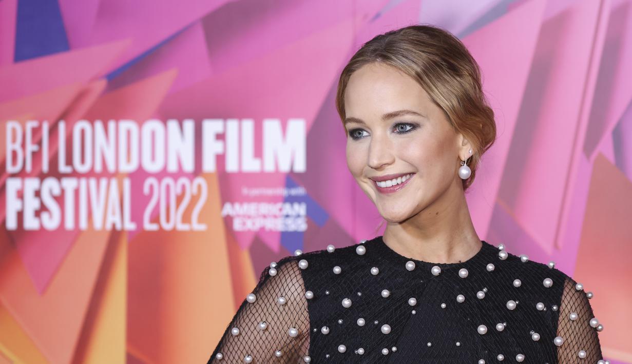 Jennifer Lawrence berpose sambil tersenyum saat menghadiri pemutaran perdana film ' Causeway' selama Festival Film London 2022 di London, Sabtu, 8 Oktober 2022. Jennifer meningkatkan tinggi badannya dengan sepatu hak hitam bertali dan melengkapi penampilannya dengan anting mutiara yang elegan. (Photo by Vianney Le Caer/Invision/AP)