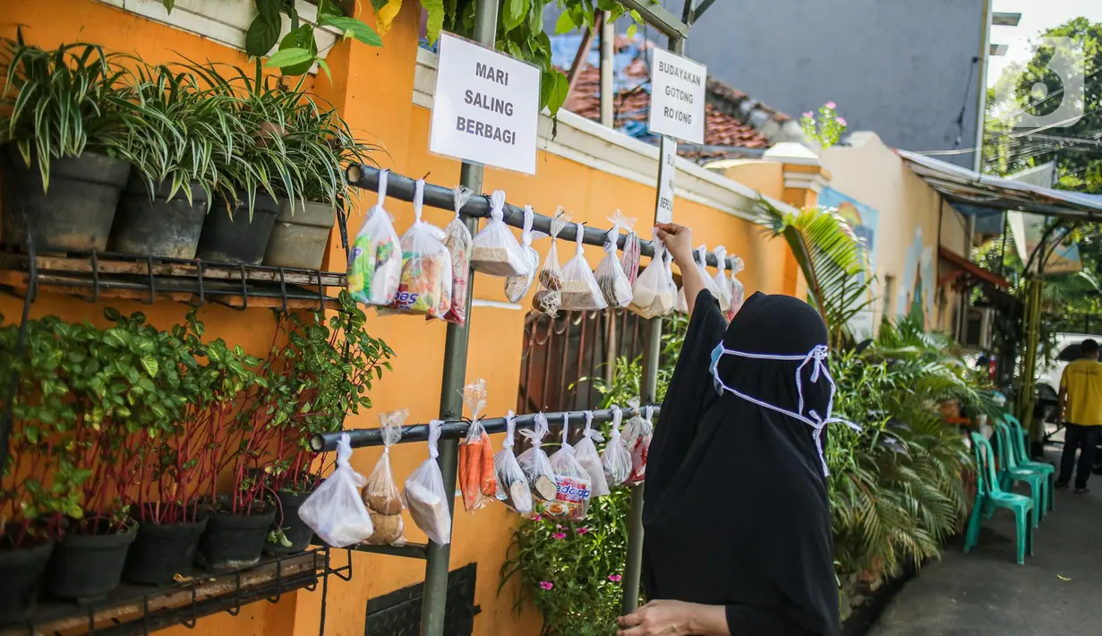 Warga memilih sayur mayur hasil sumbangan di RT 02 RW 04, Kelurahan Jati Padang, Jakarta, Jumat (22/5/2020). Pakaian bekas layak pakai serta sayur mayur disediakan bagi warga terdampak Pembatasan Sosial Berskala Besar (PSBB) untuk pencegahan COVID-19. (Liputan6.com/Faizal Fanani)