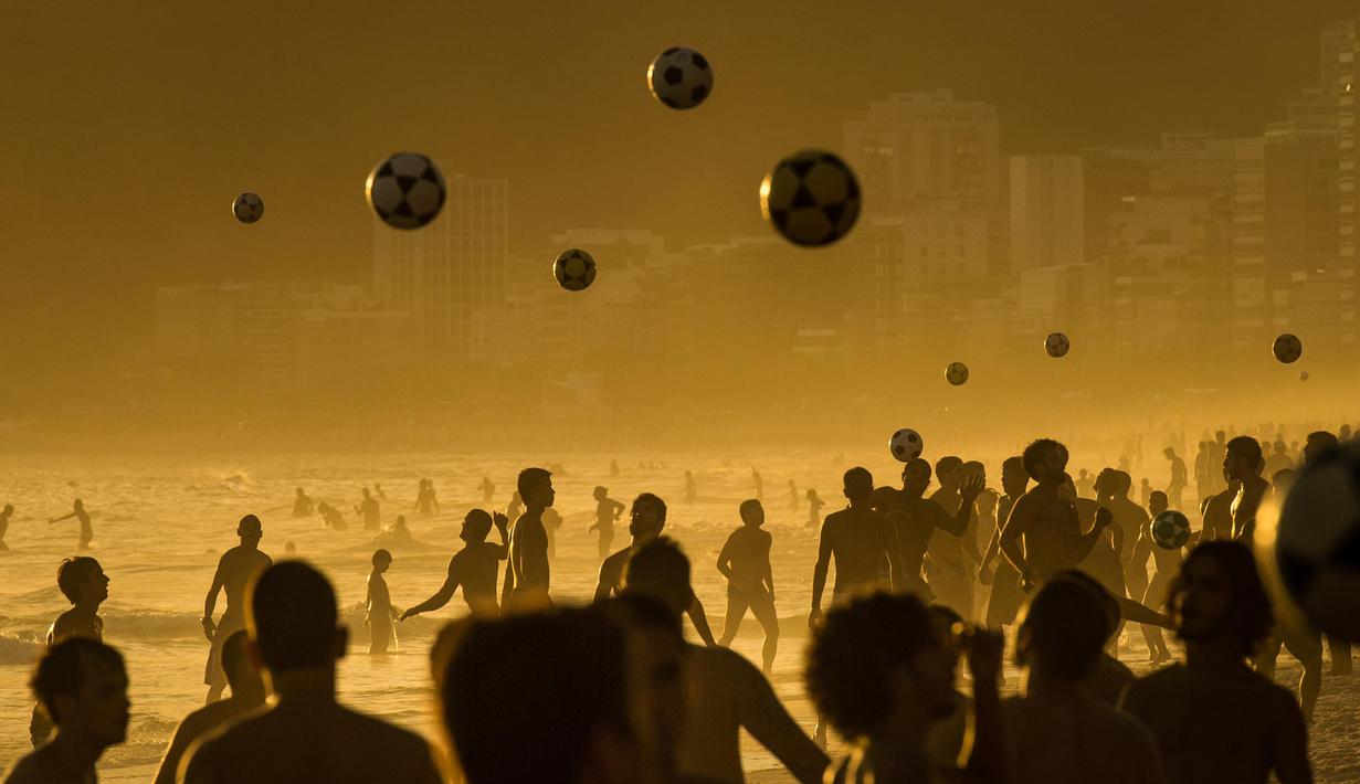 Warga bermain bola di pantai Ipanema, Rio de Janeiro, Brasil,  hampir 206 negara dan 12.500 atlet akan mengikuti 306 pertandingan dalam 28 cabang olah raga pada Olimpiade Rio 2016. (AFP/Yasuyoshi Chiba)