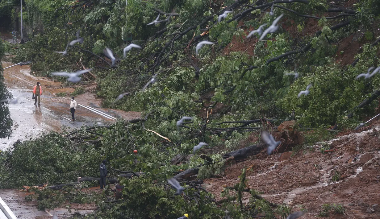 Petugas pemadam kebakaran membersihkan jalan setelah tanah longsor yang disebabkan oleh curah hujan di Mumbai, India, Rabu, (6/8/2020). Musim hujan India berlangsung dari Juni hingga September. (AP Photo / Rafiq Maqbool)