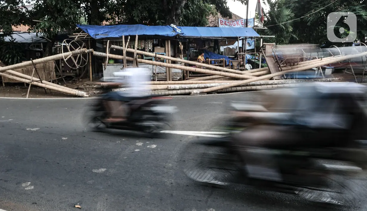 Kendaraan melintas di depan tumpukkan pohon pinang yang dijual di Jalan Manggarai Utara, Jakarta, Selasa (11/8/2020). Penjualan pohon pinang tahun ini menurun drastis dibandingkan tahun sebelumnya akibat pandemi Covid-19 yang menyebabkan larangan sejumlah perlombaan. (merdeka.com/Iqbal Nugroho)