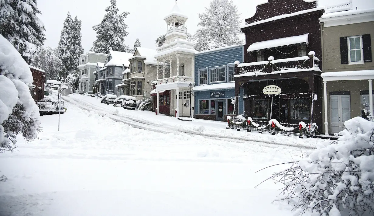 Jalanan utama yang dipenuhi salju pada Senin pagi di Nevada City, California (27/12/2021). Hujan salju dingin membuat perjalanan hampir tidak mungkin dilakukan di beberapa bagian California, Nevada. (Elias Funez/The Union via AP)