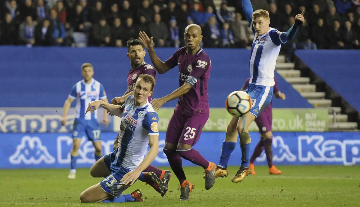 Aksi pemain Manchester City, Fernandinho (tengah) saat berebut bola dengan pemain Wigan, Dan Burn pada laga babak kelima Piala FA di DW Stadium, Wigan, (19/2/2018). Manchester City kalah 0-1.  (AP/Rui Vieira)