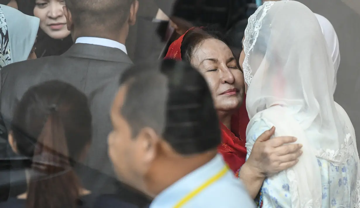 Istri mantan PM Malaysia Najib Razak, Rosmah Mansormemeluk putrinya, Nooryana Najwa Najib saat memenuhi panggilan Komisi Antikorupsi Malaysia (MACC) di Putrajaya, Selasa (6/5). Rosmah didampingi putri dan menantunya, Daniyar Kessikbayev. (AFP/Mohd RASFAN)