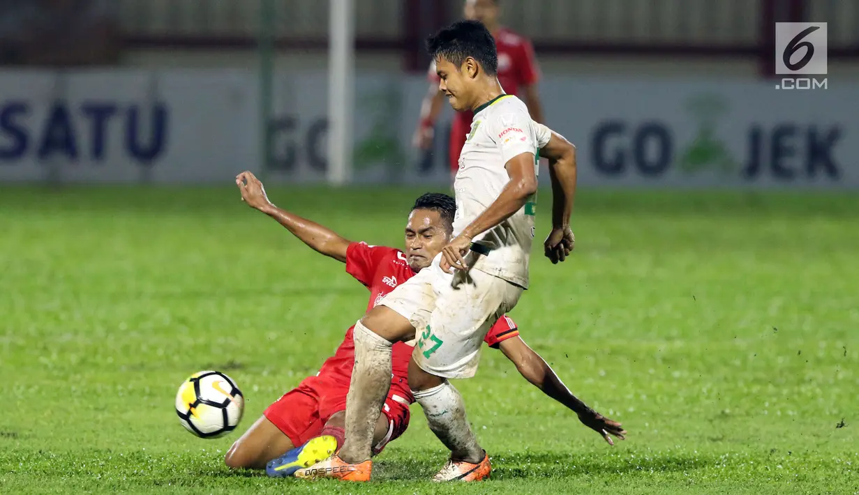 Gelandang Persija, Ramdani Lestaluhu (bawah) berebut bola dengan pemain Persebaya, Fandi Eko Utomo pada lanjutan Go-Jek Liga 1 Indonesia 2018 bersama Bukalapak di Lapangan PTIK, Jakarta, Selasa (26/6). (Liputan6.com/Helmi Fithriansyah)