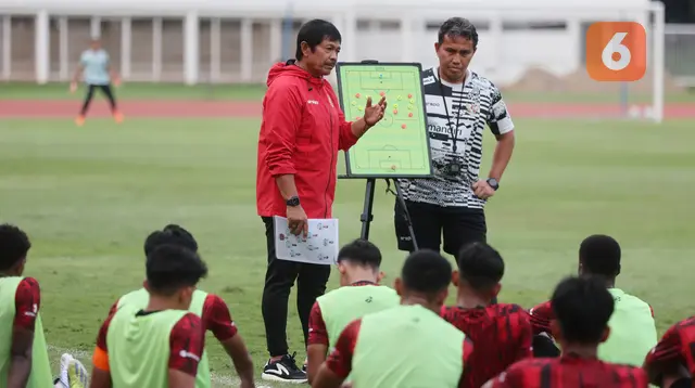 Pelatih kepala Timnas Indonesia U-19, Indra Sjafri (kiri) didampingi asisten pelatih, Bima Sakti memberi pengarahan kepada para pemainnya dalam rangkaian pemusatan latihan Timnas Indonesia U-19 di Stadion Madya, Senayan, Jakarta, Senin (1/7/2024) sebagai persiapan menghadapi ajang Piala AFF U-19 2024 yang akan berlangsung pada 17 hingga 29 Juli 2024. (Bola.com/M Iqbal Ichsan)