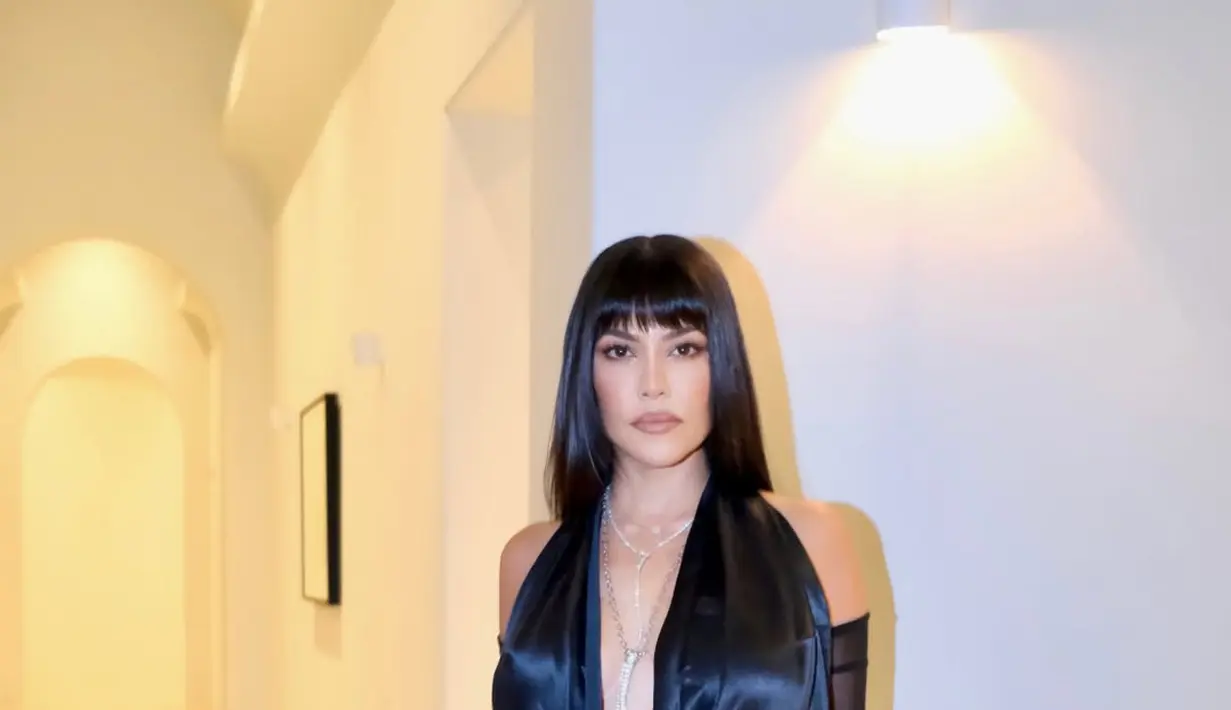 Kourtney Kardashian memilih tampil klasik dalam balutan gaun hitam panjang dengan potongan rambut bob yang elegan.  [@kourtneykardashian].