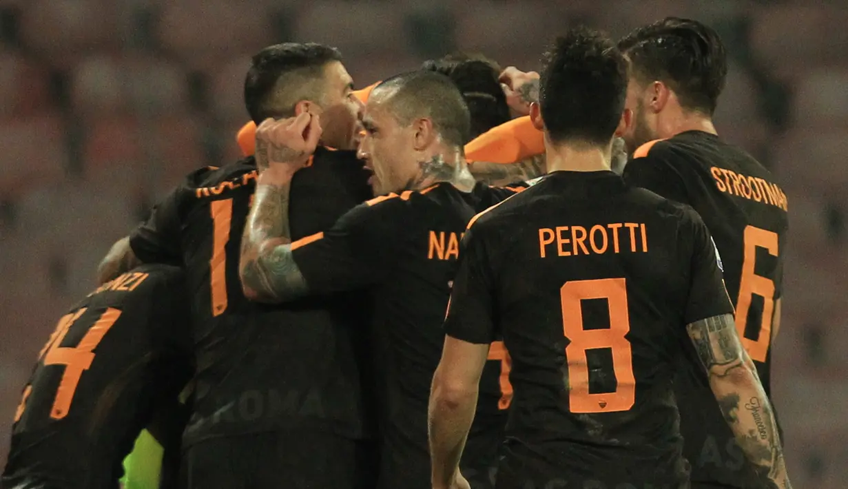 Pemain AS Roma merayakan gol keempat mereka saat melawan Napoli pada pertandingan Liga Italia Serie A di stadion San Paolo di Naples, Italia (3/3). Pada pertandingan ini AS Roma berhasil mempermalukan tuan rumah Napoli 2-4. (AFP Photo/Carlo Hermann)