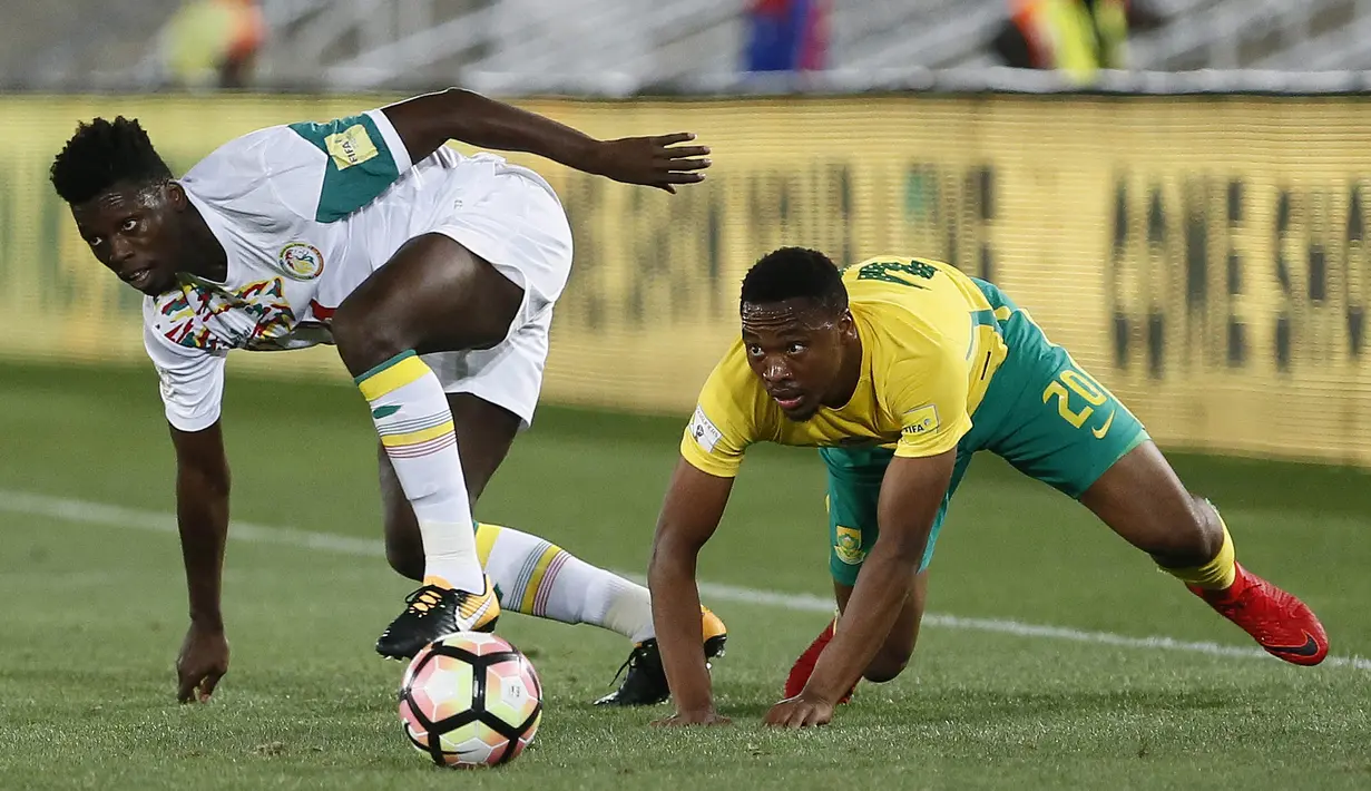 Bek Senegal, Lamine Gassama, berebut bola dengan gelandang Afrika Selatan, Sibusiso Vilakazi, pada laga kualifikasi Piala Dunia 2018 di Stadion The Peter Mokaba, Jumat (10/11/2017). Senegal menang 2-0 atas Afrika Selatan. (AFP/Phill Magakoe)