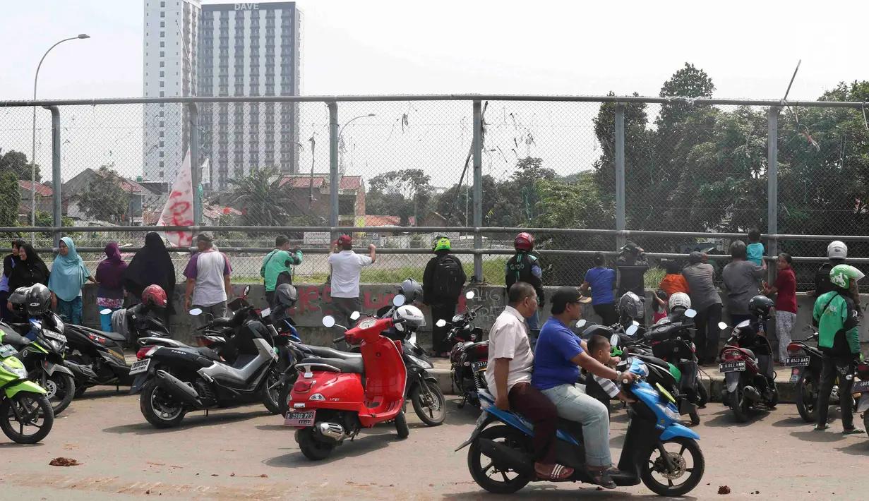 Warga berkerumun menyaksikan eksekusi bangunan rumah milik warga yang terdampak proyek Jalan Tol Cijago di kawasan Kukusan, Depok, Jawa Barat, Rabu (12/12). Di Kukusan, PN Depok kembali mengeksekusi 20 bidang lahan. (Liputan6.com/Immanuel Antonius)