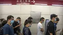 Orang-orang yang memakai masker berjalan melalui stasiun kereta bawah tanah pada jam sibuk pagi hari di Beijing, Rabu (4/8/2021). Wabah virus corona terparah di China sejak awal pandemi satu setengah tahun lalu meningkat pada Rabu dengan lusinan kasus lagi di seluruh negeri. (AP/Mark Schiefelbein)