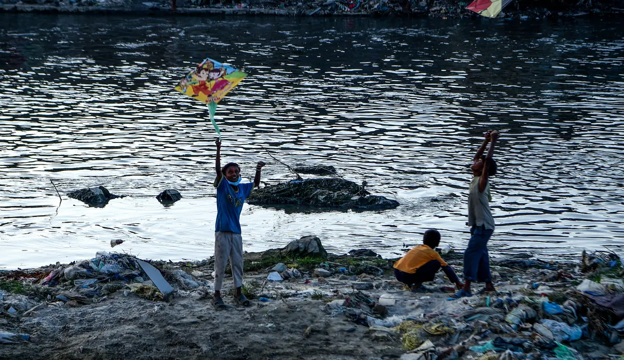 Anak laki-laki menerbangkan layang-layang di tepi sungai menjelang festival Hindu Dashain di Kathmandu (7/10/2020). Festival ini yang paling dinantikan di Nepal, Bhutan, Burma, dan perbukitan India Utara. (AFP/Prakash Mathema)