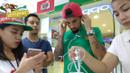 Pemain Timnas Indonesia, Stefano Lilipaly, mencoba mendengarkan suara dari telepon seluler yang diminatinya di sebuah pusat perbelanjaan di Makati City, Manila, Filipina, Minggu (20/11/2016). (Bola.com/Nicklas Hanoatubun)