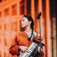 Penyanyi kelahiran tahun 1993 ini tampil dengan penuh penghayatan. Masih ditemani keyboard kesayangannya, dengan pakaian berwarna putih bercorak bunga-bunga dan outer berwarna oranye, ia tampak menawan dengan rambut dikepang (Liputan6.com/IG/@isyanasarasvati)