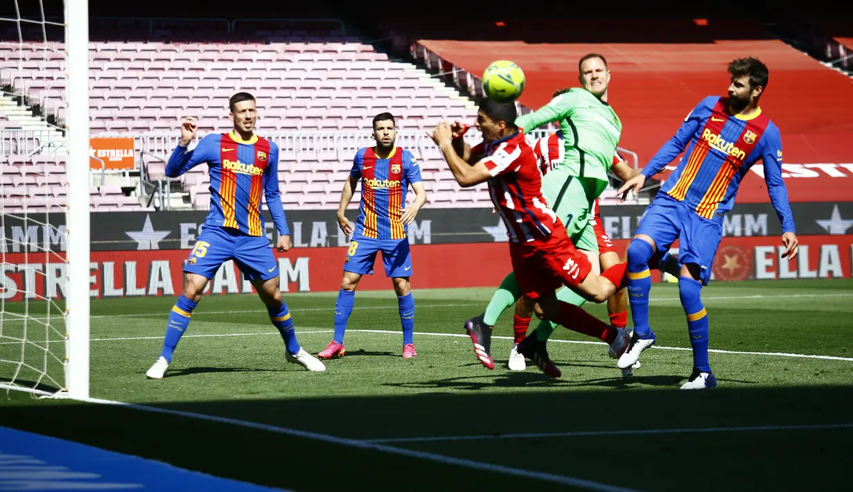 Penyerang Atletico Madrid, Luis Suarez berusaha menyundul bola dari kawalan kiper Barcelona, Marc-Andre ter Stegen pada pertandingan La Liga Spanyol di stadion Camp Nou, Spanyol, Sabtu (8/5/2021). Urutan ketiga ditempati  Real Madrid yang baru mengumpulkan 74 poin. (AP Photo / Joan Monfort)