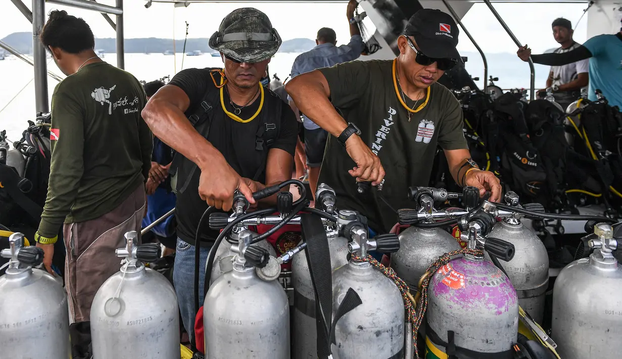 Penyelam memeriksa tangki oksigen saat bersiap melanjutkan pencarian korban kapal wisata yang terbalik di dermaga Chalong, Phuket, Sabtu (7/7). Kapal Phoenix yang membawa 105 penumpang tenggelam di Laut Andaman pada Kamis sore. (AFP/Mohd RASFAN)