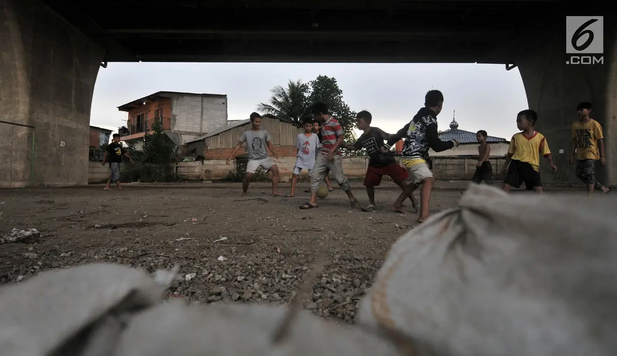 Anak-anak bermain sepak bola di kolong jalan Tol Lingkar Utara, Kalibaru, Cilincing, Jakarta, Kamis (28/3). Pemkot Jakarta Utara akan membangun Taman Maju Bersama (TMB) di kolong tol tersebut untuk mengurangi ruang kumuh serta menjadi sarana rekreasi warga dan anak-anak (merdeka.com/Iqbal S Nugroho)