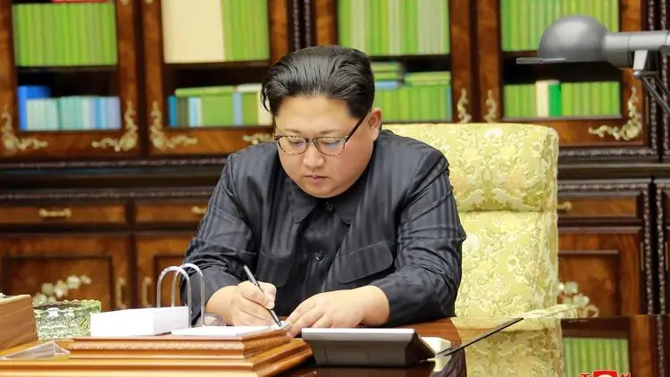 Media corong rezim Korut, Korean Central News Agency menunjukkan Kim Jong-un sedang menandatangi perintah peluncuran rudal (AFP)