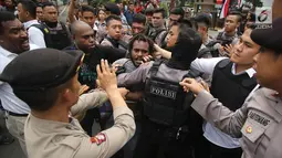 Polisi terlibat aksi saling dorong saat berusaha membubarkan massa FRI-WP dan AMP di Jalan Medan Merdeka Barat, Jakarta, Selasa (15/8). Kericuhan terjadi akibat polisi melarang aksi di depan Istana Negara. (Liputan6.com/Immanuel Antonius)