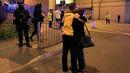 Sejumlah orang bereaksi menyusul ledakan yang terjadi di dalam arena konser penyanyi Ariana Grande di Manchester, Inggris, Senin (22/5). Bintang pop Ariana Grande dilaporkan dalam kondisi baik menyusul ledakan dalam konsernya itu. (Peter Byrne/PA via AP)