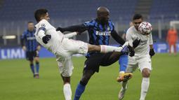 Bek Real Madrid, Raphael Varane, berebut bola dengan penyerang Inter Milan, Romelu Lukaku, pada laga lanjutan Liga Champions di Giuseppe Meazza, Kamis (26/11/2020) dini hari WIB. Real Madrid menang 2-0 atas Inter Milan. (AP Photo/Luca Bruno)