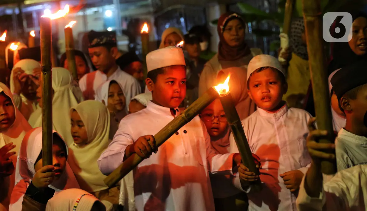 Anak-anak membawa obor sambil berkeliling kampung di kawasan Kota Tangerang, Banten, Jumat (29/7/2022) malam. Pawai obor tersebut digelar untuk menyambut malam pergantian Tahun Baru Islam atau 1 Muharam 1444 H. (Liputan6.com/Angga Yuniar)