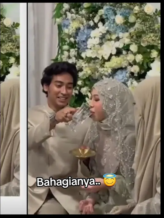 Potret bahagia Abidzar menggantikan peran sang ayah. Tampak anak kedua mendiang Uje tersebut juga meledek sang kakak yang akan diberi minum. Gelasnya diangkat semakin ke atas dan membuat Adiba tersenyum melihat keisengan adiknya.  [TikTok/@ninimihairani]