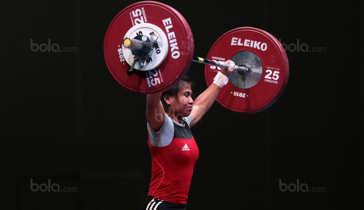 Senyum Sri Wahyuni saat turun pada kelas 48 kg di Hall A Arena PRJ, Jakarta, Rabu (11/2/2018). Sri Wahyuni meraih medali emas dengan total angkatan 187 kg. (Bola.com/Nicklas Hanoatubun)